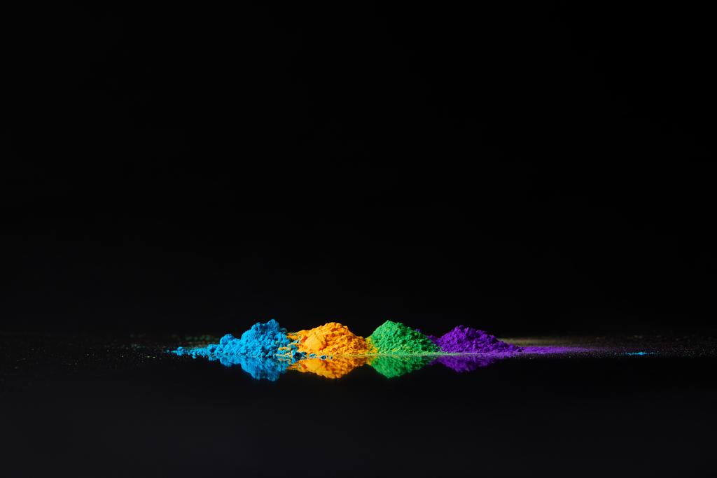 quattro colori di holi in polvere per la festa di primavera indù, su nero con riflesso
 - Foto, immagini