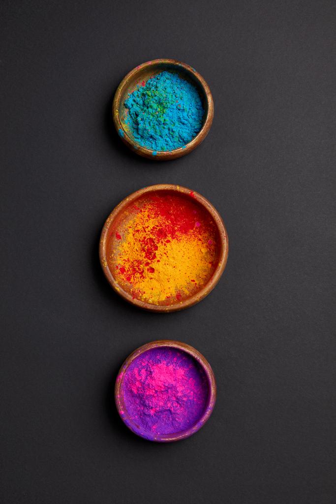 Widok z góry holi kolorowe proszku w miski w wierszu na powierzchni szary  - Zdjęcie, obraz