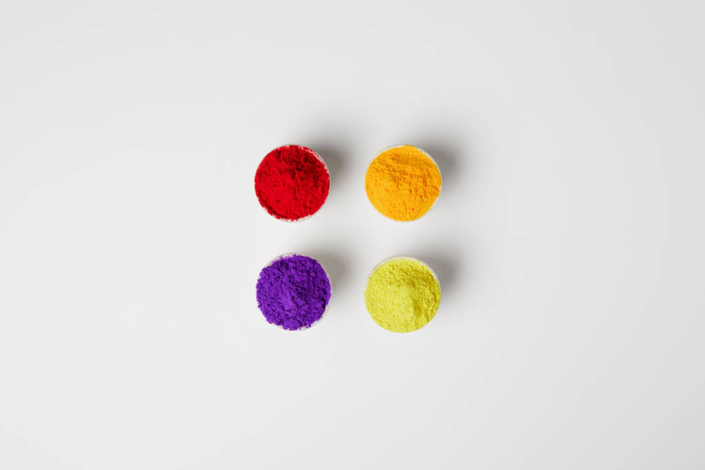 vue de dessus de quatre couleurs de poudre holi dans des bols sur blanc, festival de printemps hindou
 - Photo, image