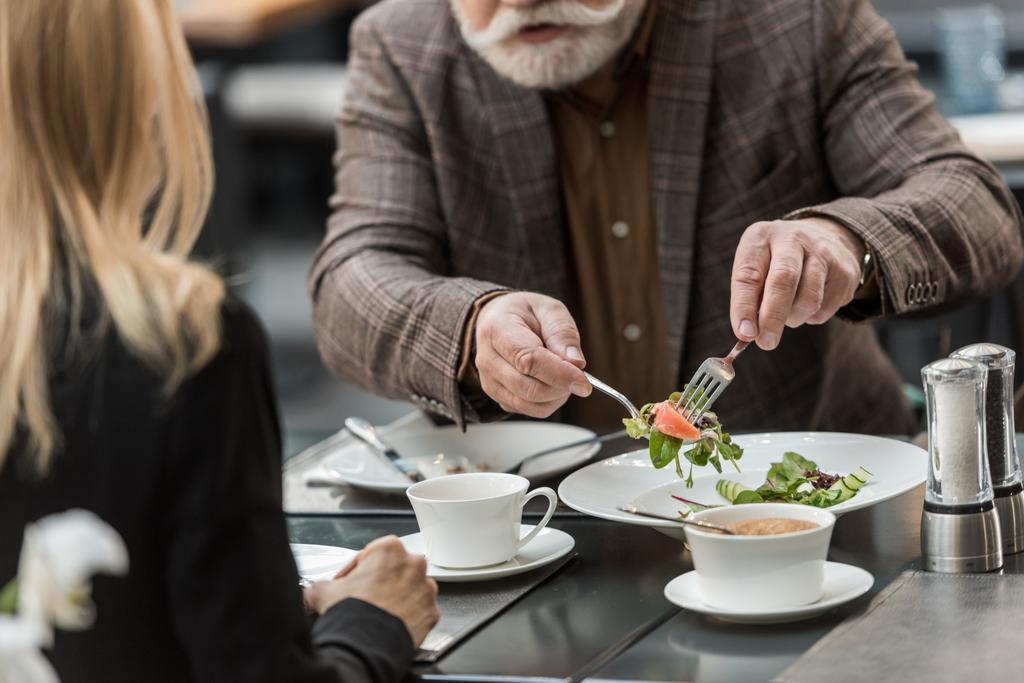 częściowy widok mężczyzny i kobiety razem mając na obiad w restauracji - Zdjęcie, obraz