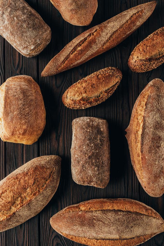 felülnézete rendezett loafs a fa felületén kenyér - Fotó, kép