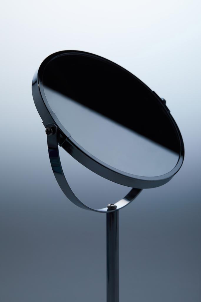close-up de espelho cosmético com suporte em cinza
 - Foto, Imagem