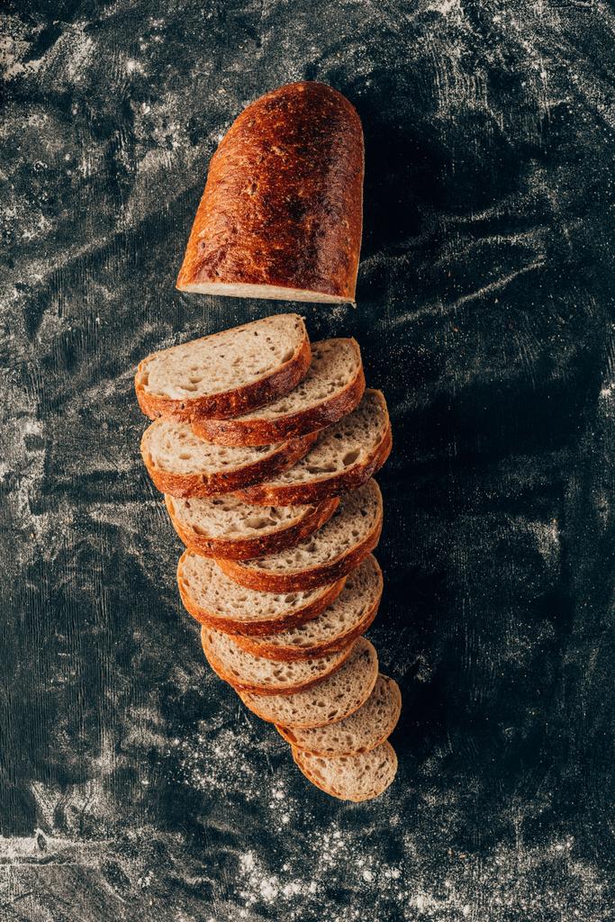 pohled shora uspořádány kousky chleba na tmavý povrch s moukou - Fotografie, Obrázek
