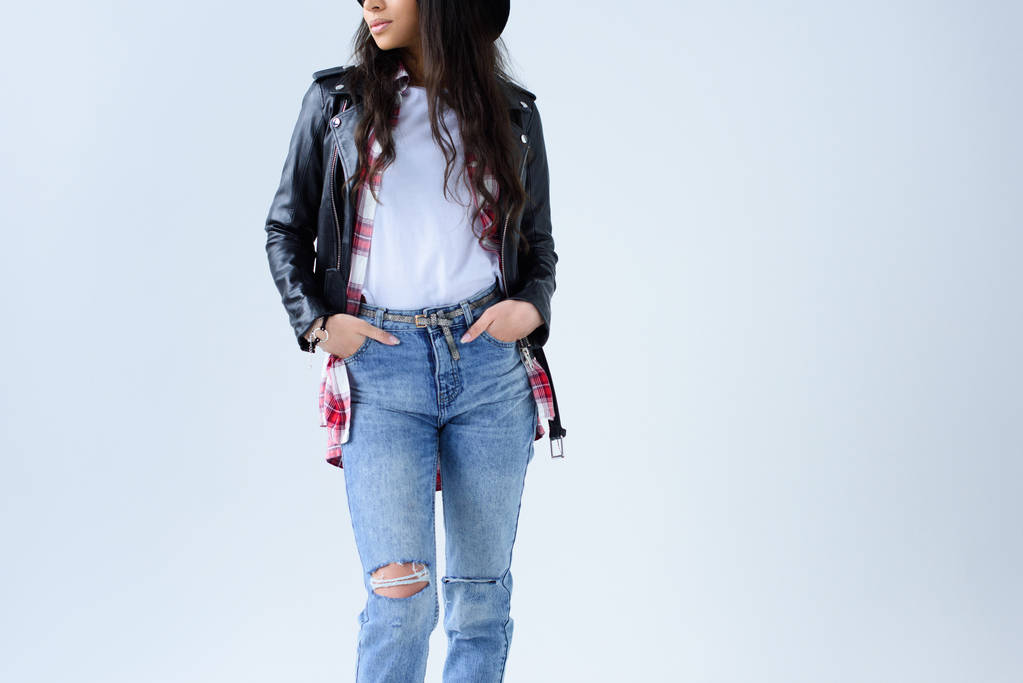 Schnappschuss einer stylischen jungen Frau in Lederjacke und Jeans isoliert auf grau - Foto, Bild