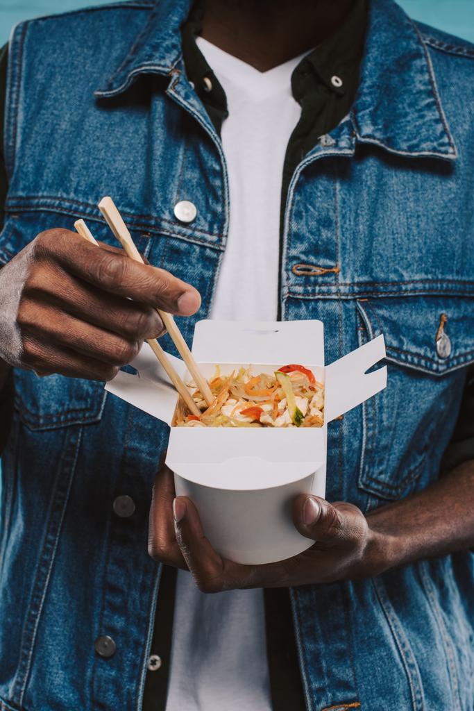 vágott szemcsésedik-ból afrikai amerikai férfi, gazdaság box kínai étel hazavitelre tészta - Fotó, kép