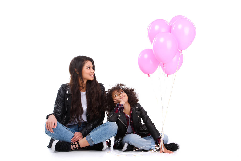 madre e hija en chaquetas de cuero con manojo de globos rosados aislados en blanco
 - Foto, Imagen