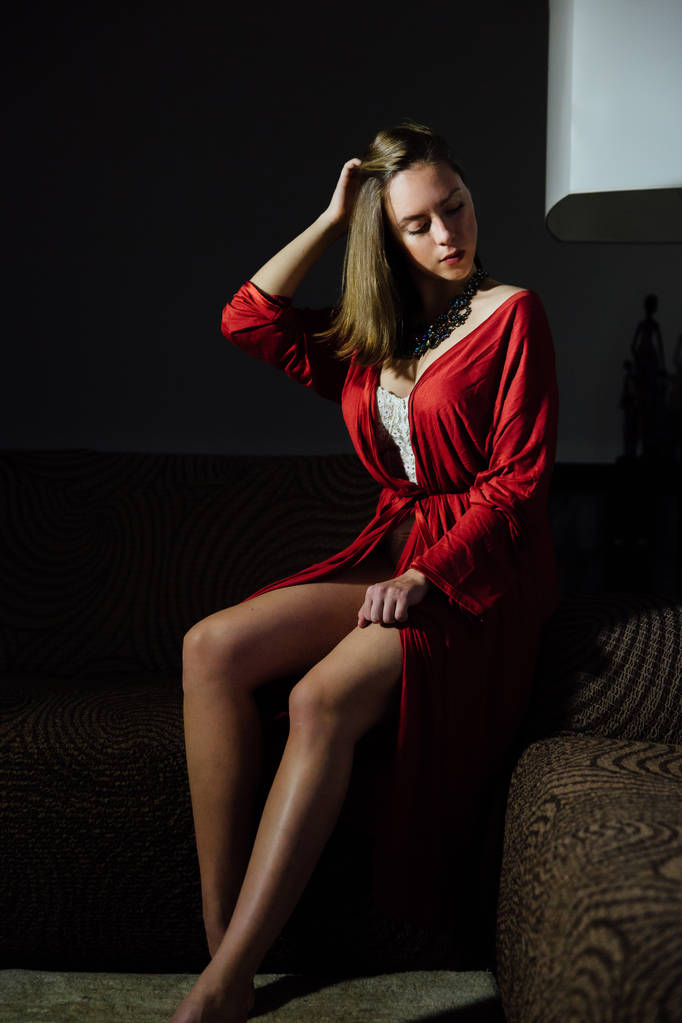 Красива сексуальна леді в елегантному червоному халаті. Модний портрет моделі в приміщенні
. - Фото, зображення