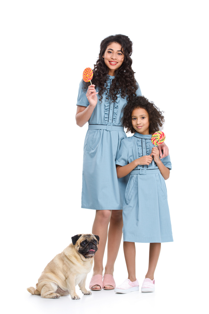 mother and daughter with lollipop candies and pug isolated on white - Photo, Image