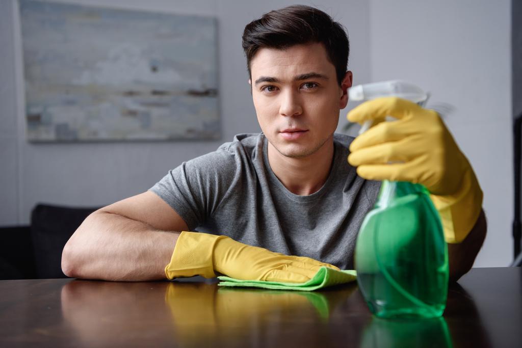 handsome man holding spray bottle and rag - Photo, Image