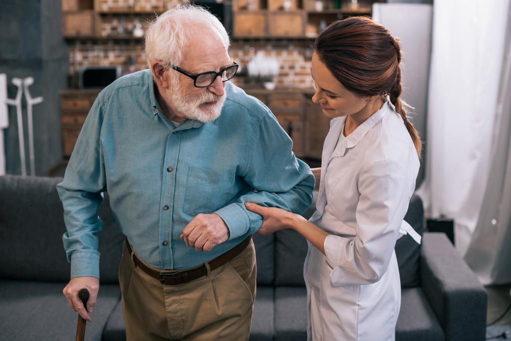 Docteur tenant la main d'un homme âgé avec canne
 - Photo, image