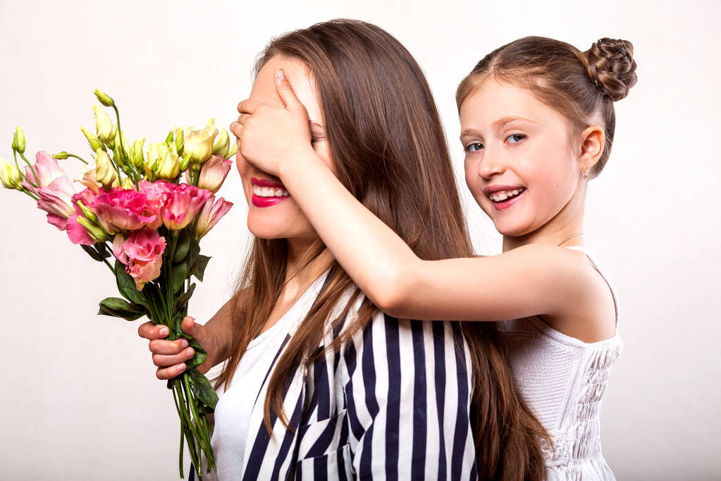 dochter geeft haar moeder bloemen in de studio, gelukkig Moederdag - Foto, afbeelding