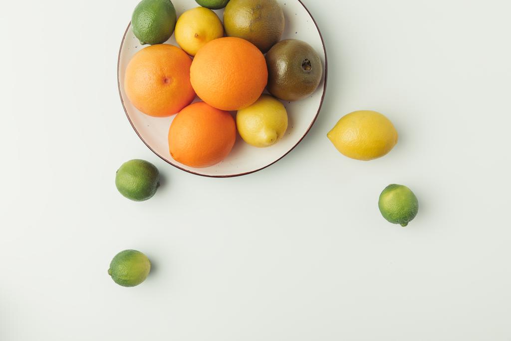 bovenaanzicht van sappige citruses op plaat geïsoleerd op witte achtergrond - Foto, afbeelding