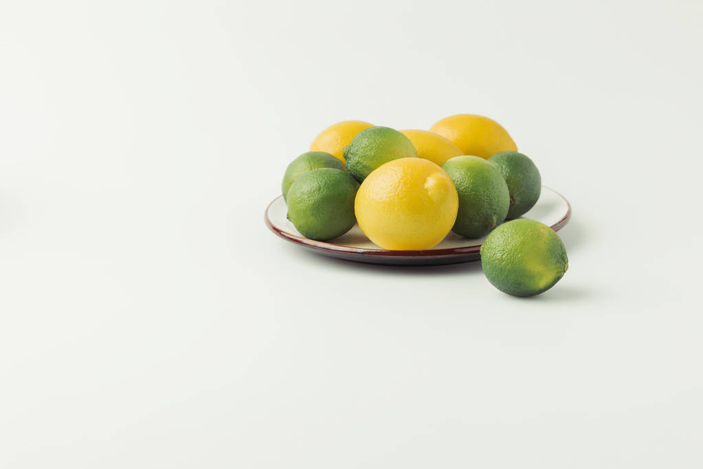 Citrus fruits on plate on white background - Photo, Image