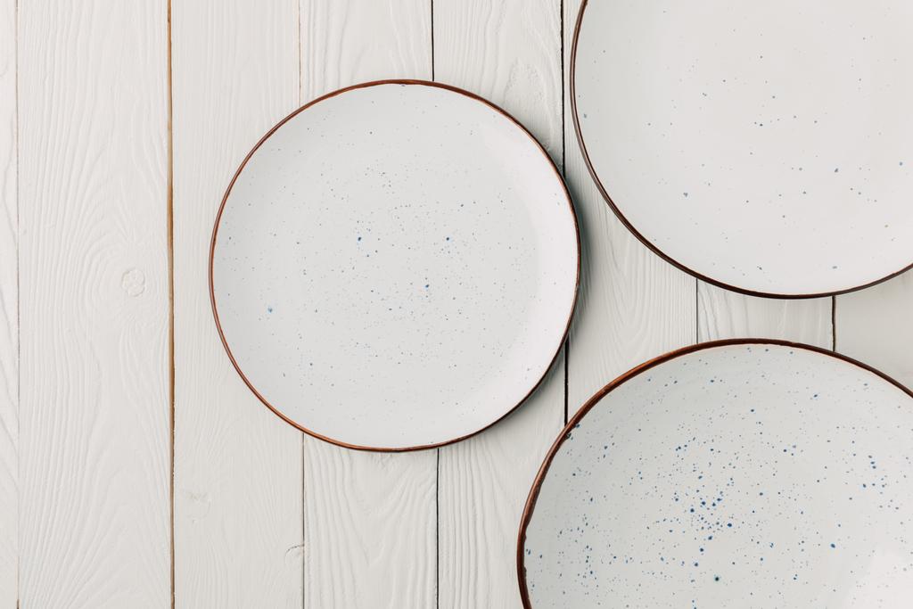 Placas esmaltadas de cerámica sobre fondo blanco de madera
 - Foto, Imagen