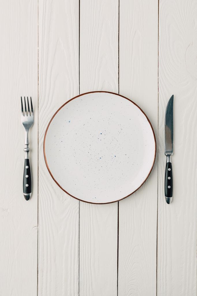Pohled shora na talíř a příbory na bílém pozadí dřevěná - Fotografie, Obrázek