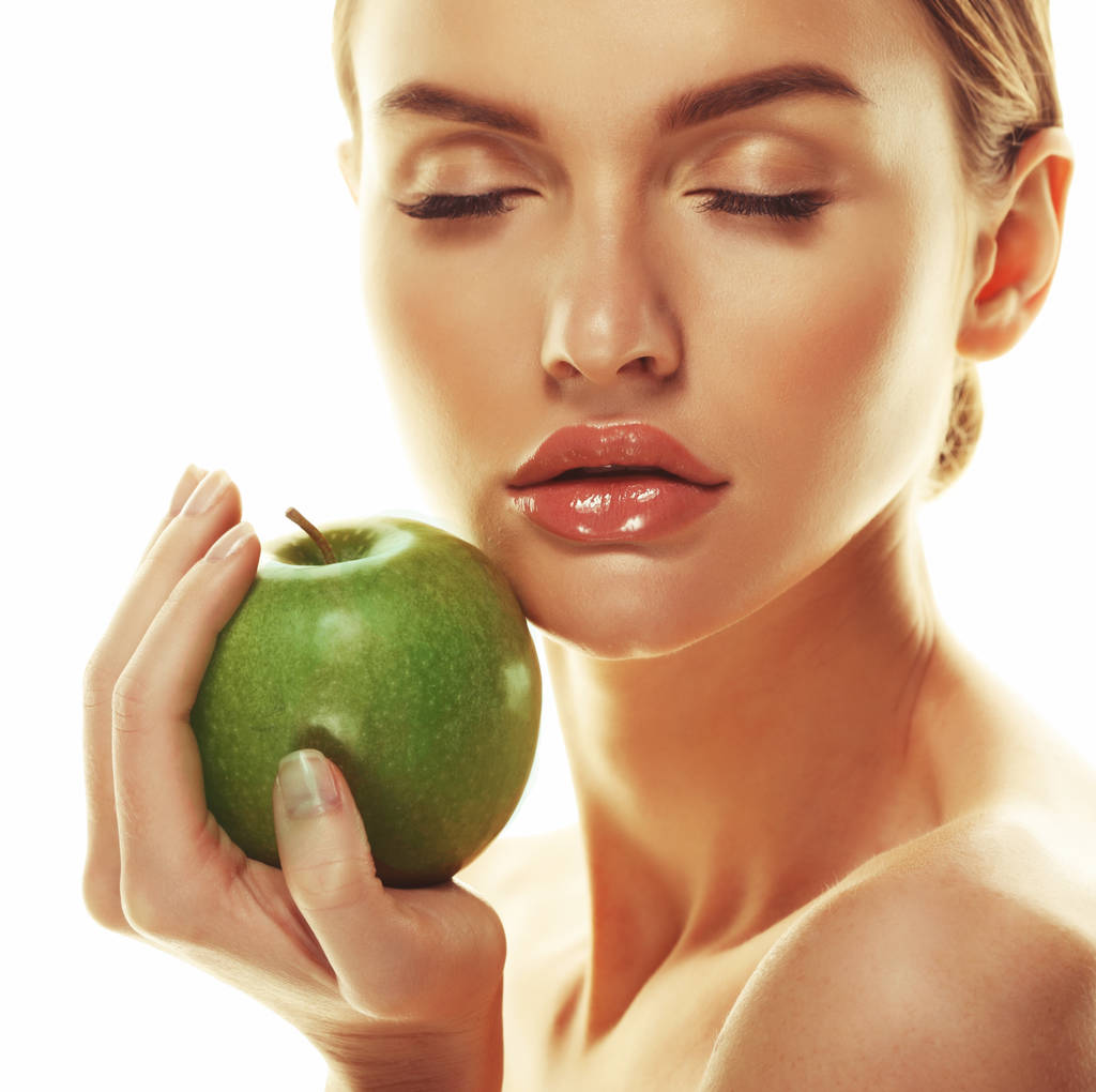 緑のリンゴを持つ若い幸せな女性-白に隔離された - 写真・画像