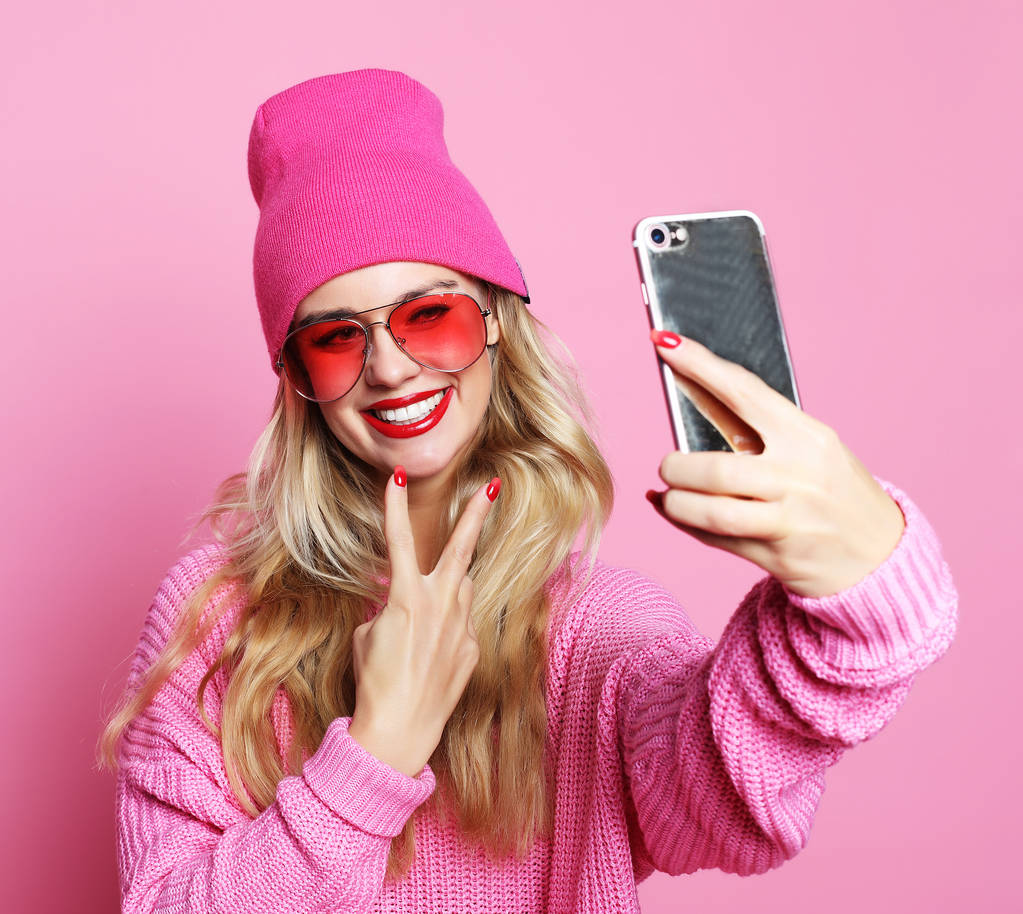 Chica de la moda tomando fotos hace autorretrato en el teléfono inteligente wea
 - Foto, Imagen