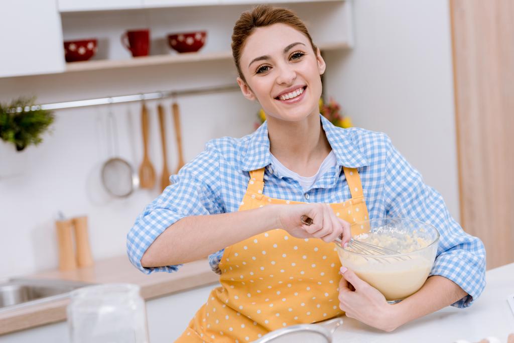 привлекательная молодая женщина смешивает тесто для выпечки на кухне
 - Фото, изображение