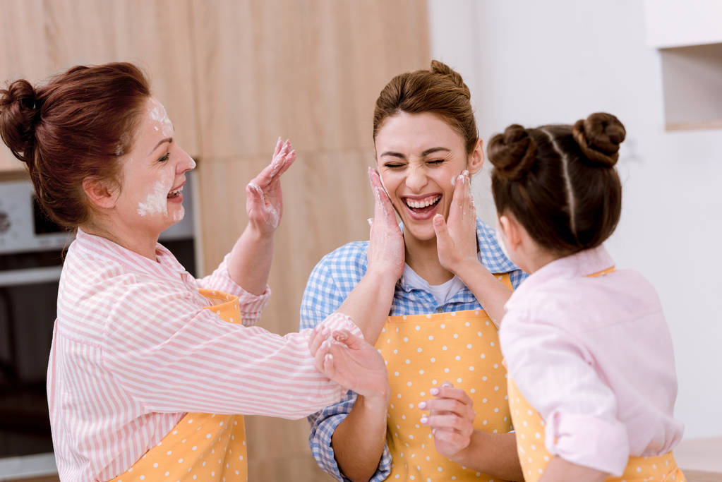 три покоління смішних жінок, які грають з борошном на кухні
 - Фото, зображення
