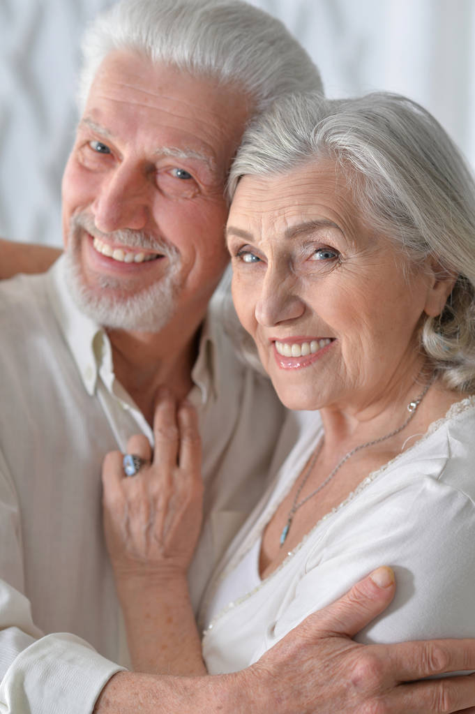 Porträt eines glücklichen Senioren-Paares, das sich zu Hause umarmt - Foto, Bild