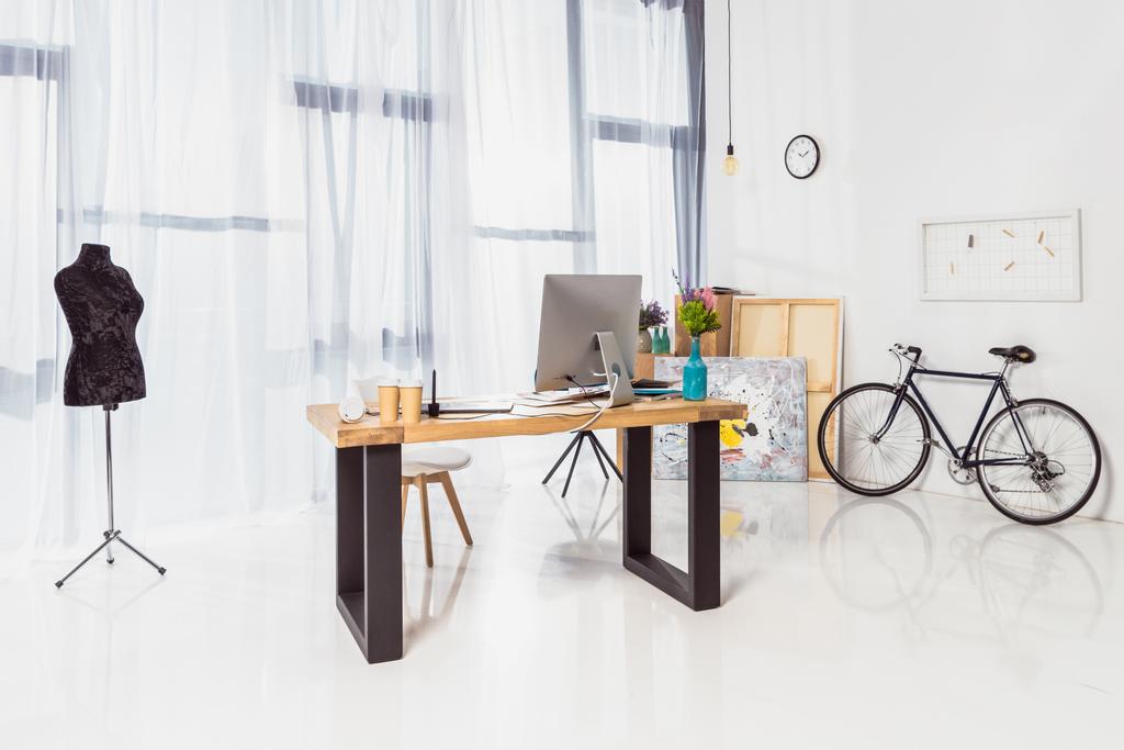 Spacious home office with working table and bicycle - Photo, Image