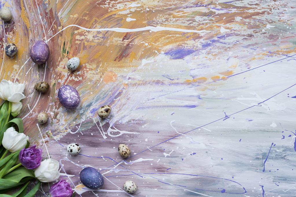 zarte Frühlingstulpen und gefärbte Eier auf fleckigem Hintergrund - Foto, Bild