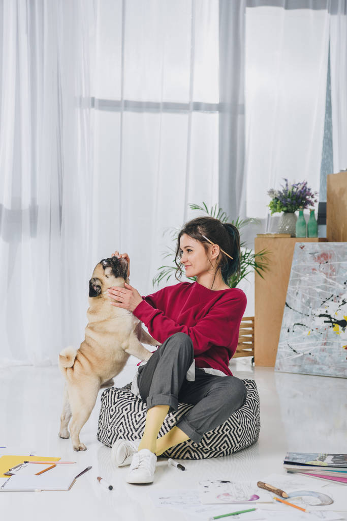 Красивая леди играет с собакой на полу домашнего офиса
 - Фото, изображение