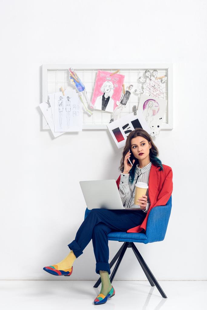 Atraktivní mladá dívka mluví po telefonu při práci na notebooku - Fotografie, Obrázek
