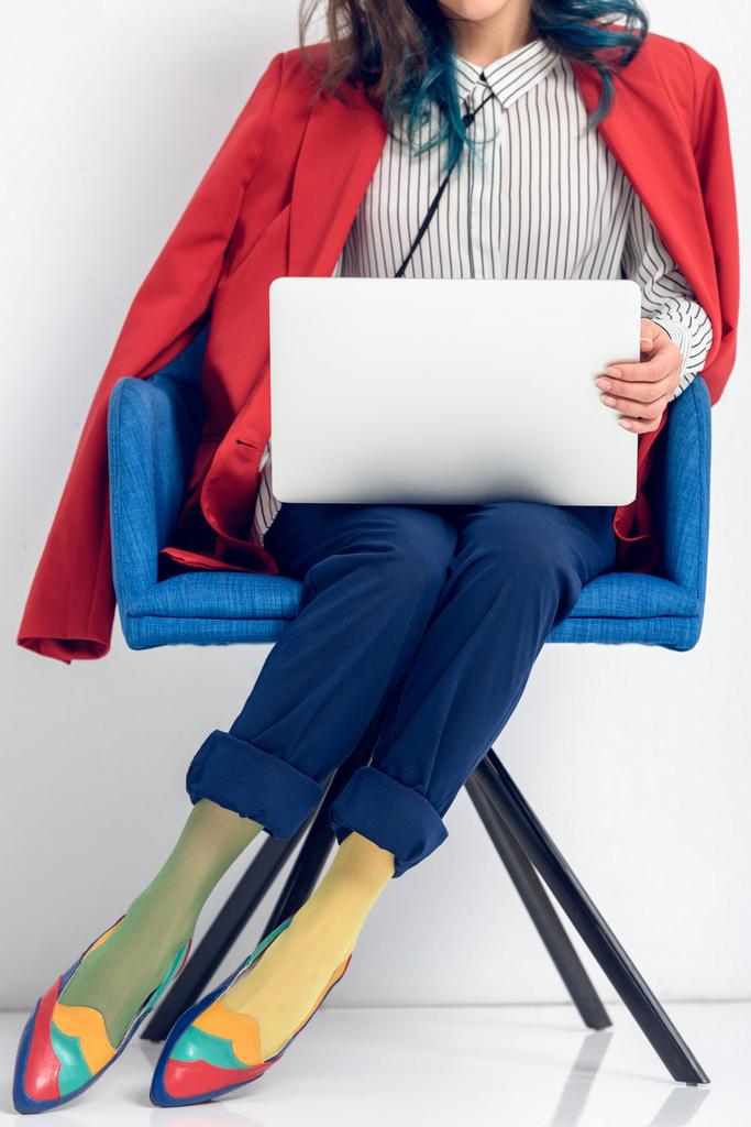 椅子に座りながらノート パソコンに取り組んでいる若い女の子のクローズ アップ ビュー - 写真・画像