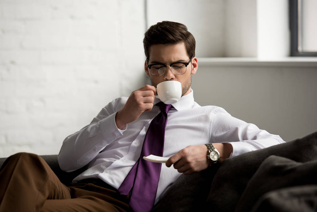 Εμπρόσθια όψη του νεαρός επιχειρηματίας πίνοντας καφέ - Φωτογραφία, εικόνα