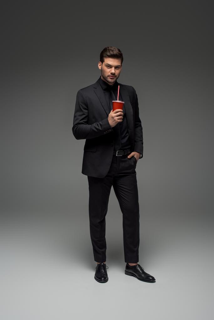  homme d'affaires élégant avec tasse jetable sur gris
 - Photo, image