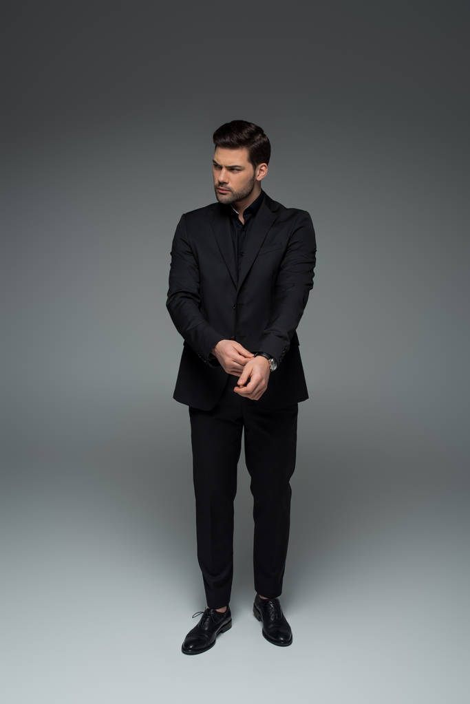 Elegantní muž v černém obleku, oprava hodinky Grey - Fotografie, Obrázek