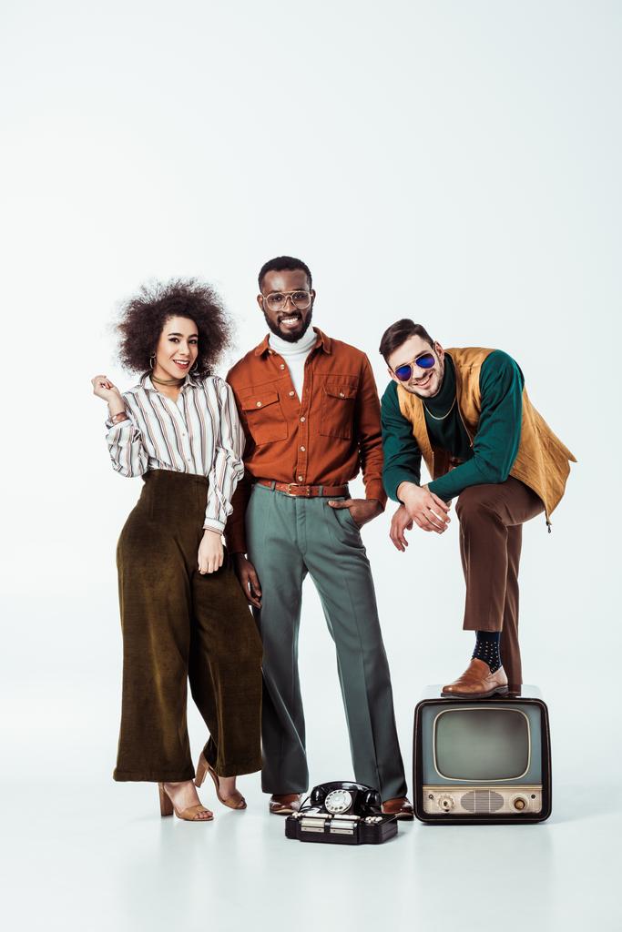 smiling multicultural retro styled friends with vintage television looking at camera on white - Photo, Image