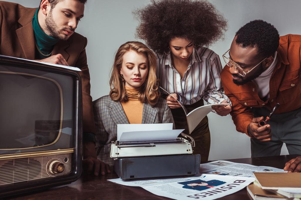 Multikulturelle Freunde im Retro-Stil arbeiten isoliert auf grau im Newsroom - Foto, Bild