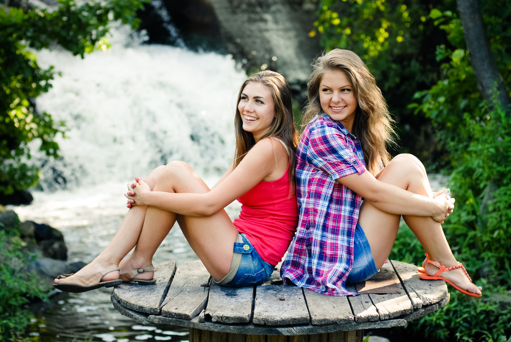 Дві дівчини-підлітки сидять біля водоспаду
 - Фото, зображення