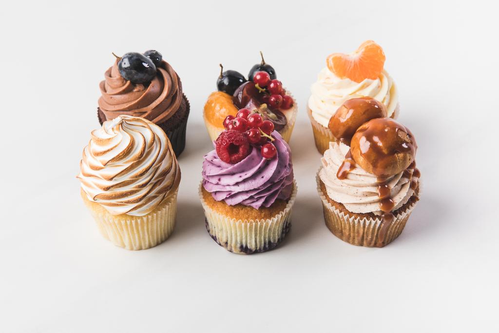 vista de perto de vários cupcakes doces isolados em branco
 - Foto, Imagem