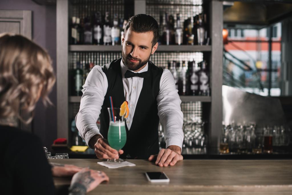 handsome bartender giving cocktail to girl - Photo, Image