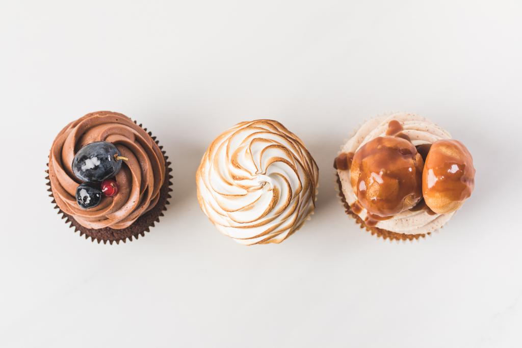 vista dall'alto di disposizione di gustosi cupcake isolati su bianco
 - Foto, immagini