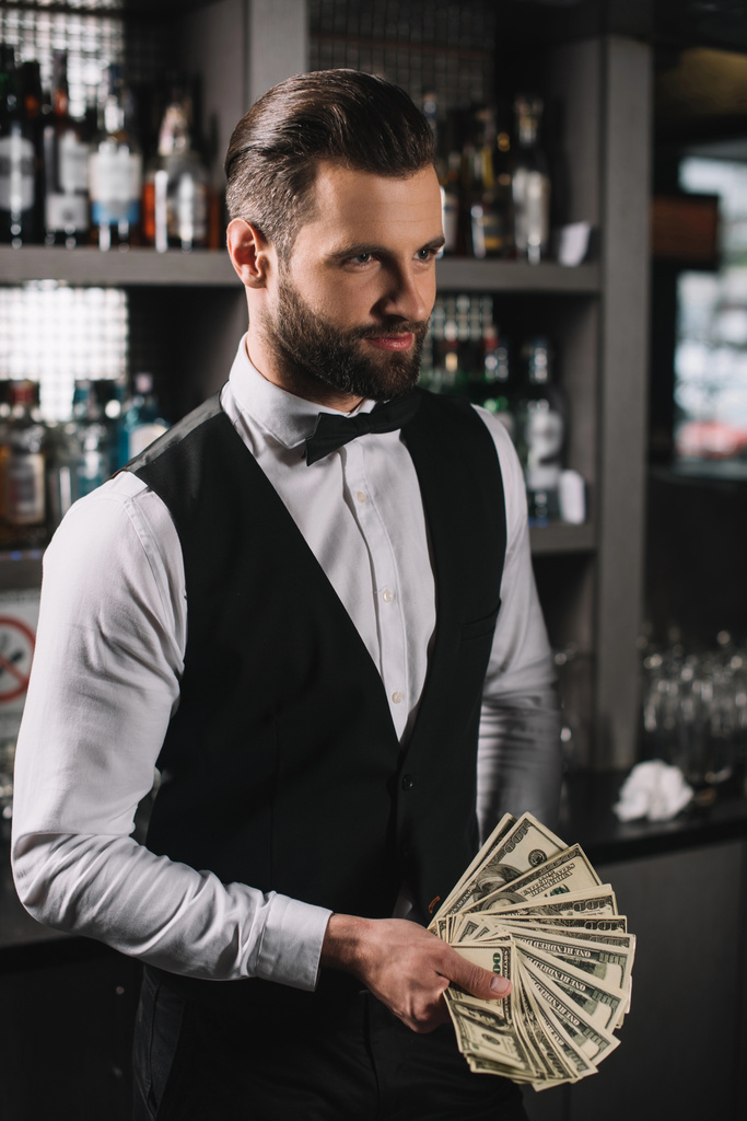 Happy Handsome Bartender Holding Tips At Bar Free Stock Photo and Image