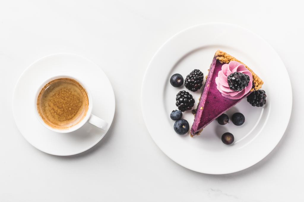 vista dall'alto di un pezzo di torta con bacche e tazza di caffè isolato su un tavolo bianco
 - Foto, immagini