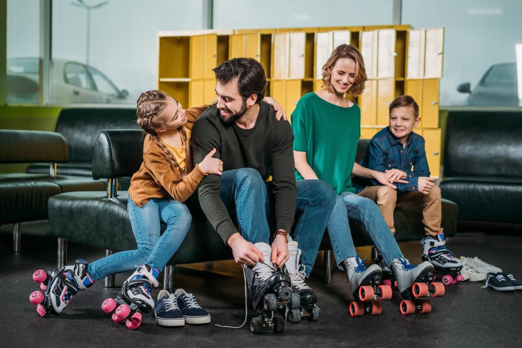 семья отдыхает на диване перед катанием на роликовых коньках в скейт-парке
 - Фото, изображение