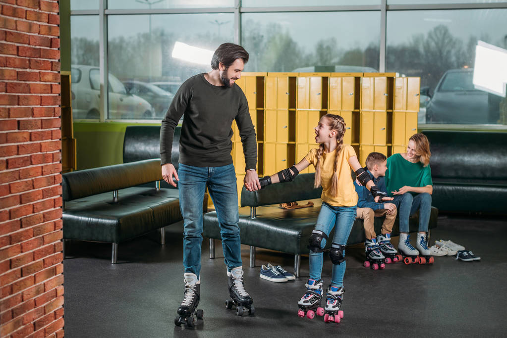 Vater und Tochter auf Rollschuhbahn im Skatepark - Foto, Bild