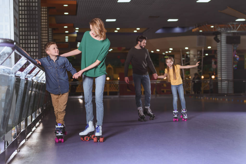 pais e crianças patinando na pista de patins juntos
 - Foto, Imagem