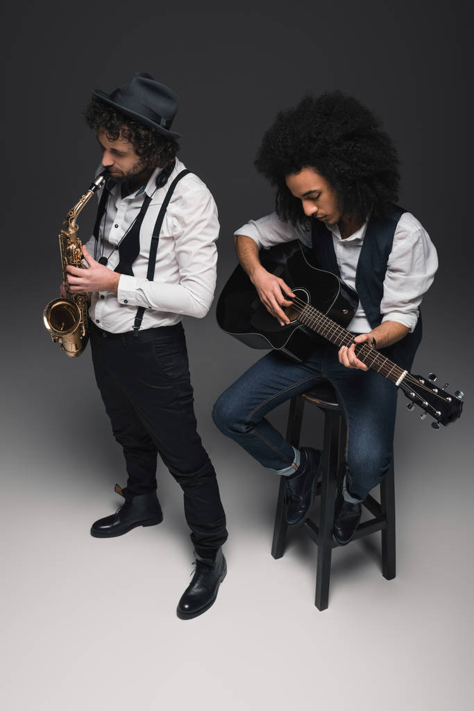 visão de alto ângulo de dueto de músicos tocando sax e guitarra acústica
 - Foto, Imagem