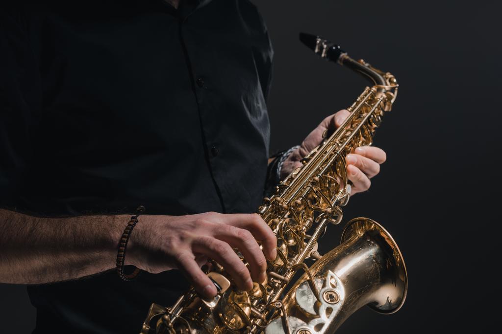 cropped shot of man playing saxophone on black - Photo, Image