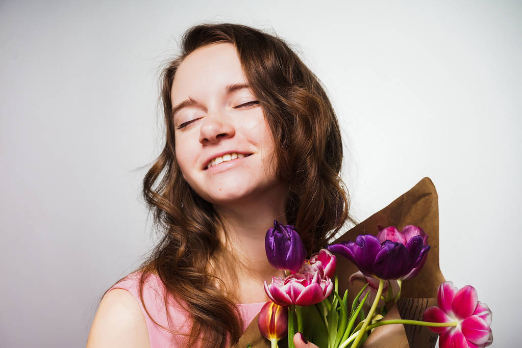 happy young woman holding a big bouquet of flowers, celebrating the world women 's day, March 8
 - Фото, изображение