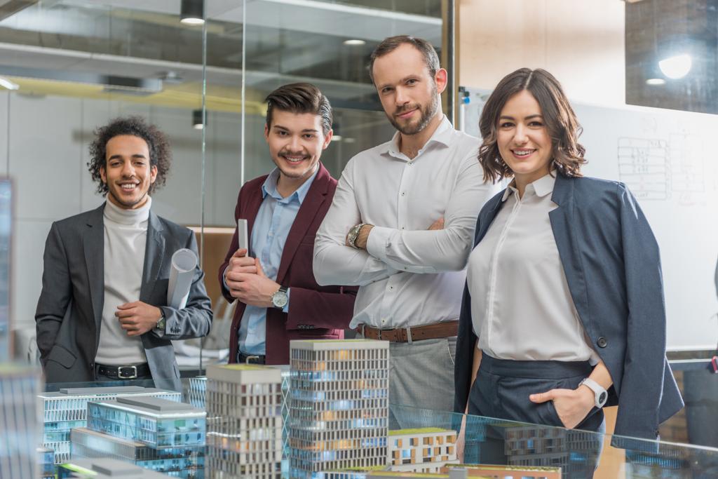 groep van gelukkig architecten staan naast de modellen op kantoor gebouw - Foto, afbeelding