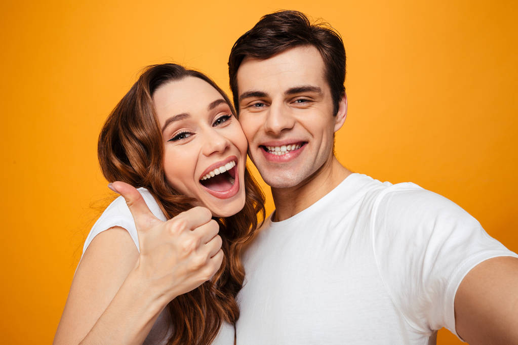 Young lovely couple posing together while making selfie and woma - Photo, Image