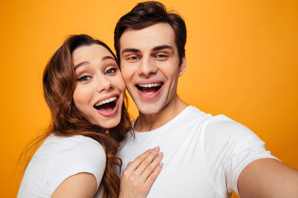 Portrait of happy man and woman in white t-shirts smiling and po - Photo, Image