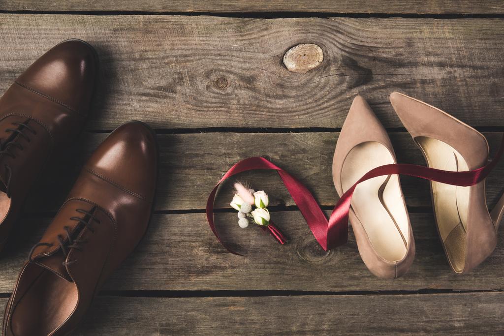 επίπεδη lay με κορδέλα, κορσάζ, νυφικό και γαμπρούς παπούτσια σε ξύλινη επιτραπέζια - Φωτογραφία, εικόνα
